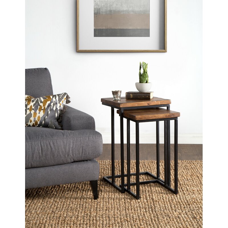 nesting tables set with wood tops and metal frames, next to a sofa